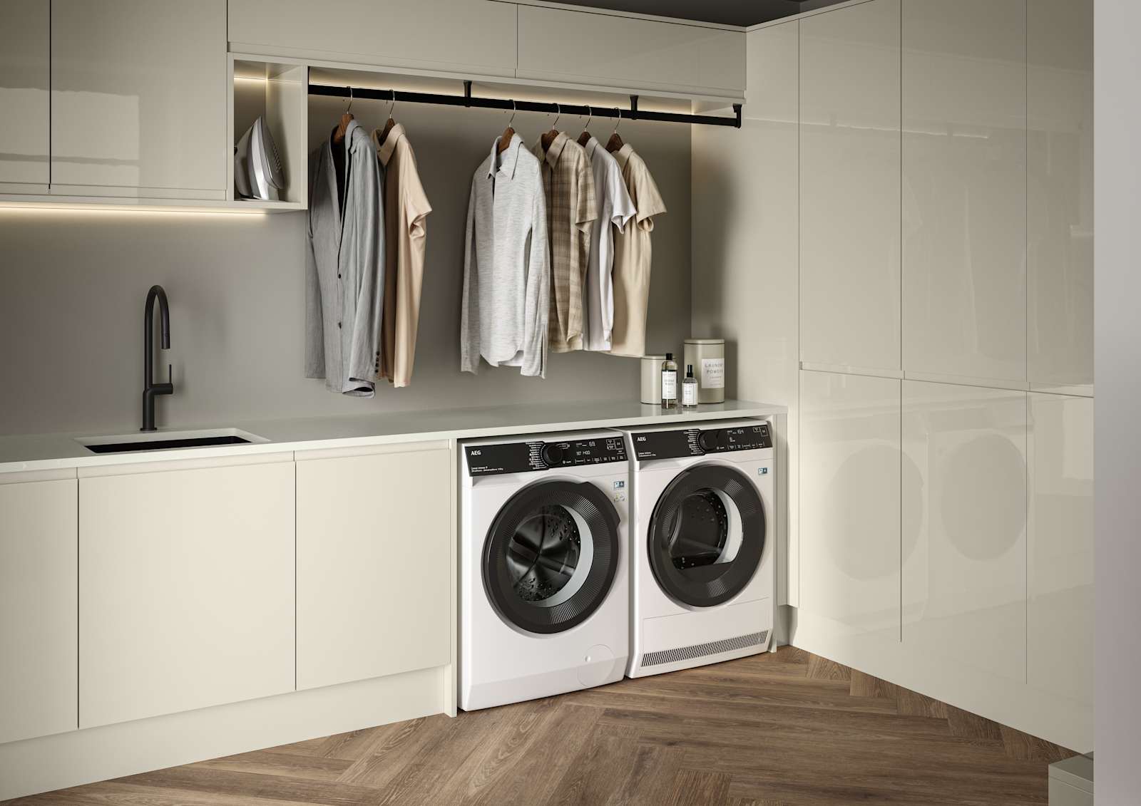 Contemporrary and elegant Luna Gloss Limestone kitchen with integrated washing machine and tumble dryer, tall cabinets, coat hanger under top cabinets and a black sink matched with black tap and Amtico smouldering oak parquet flooring.