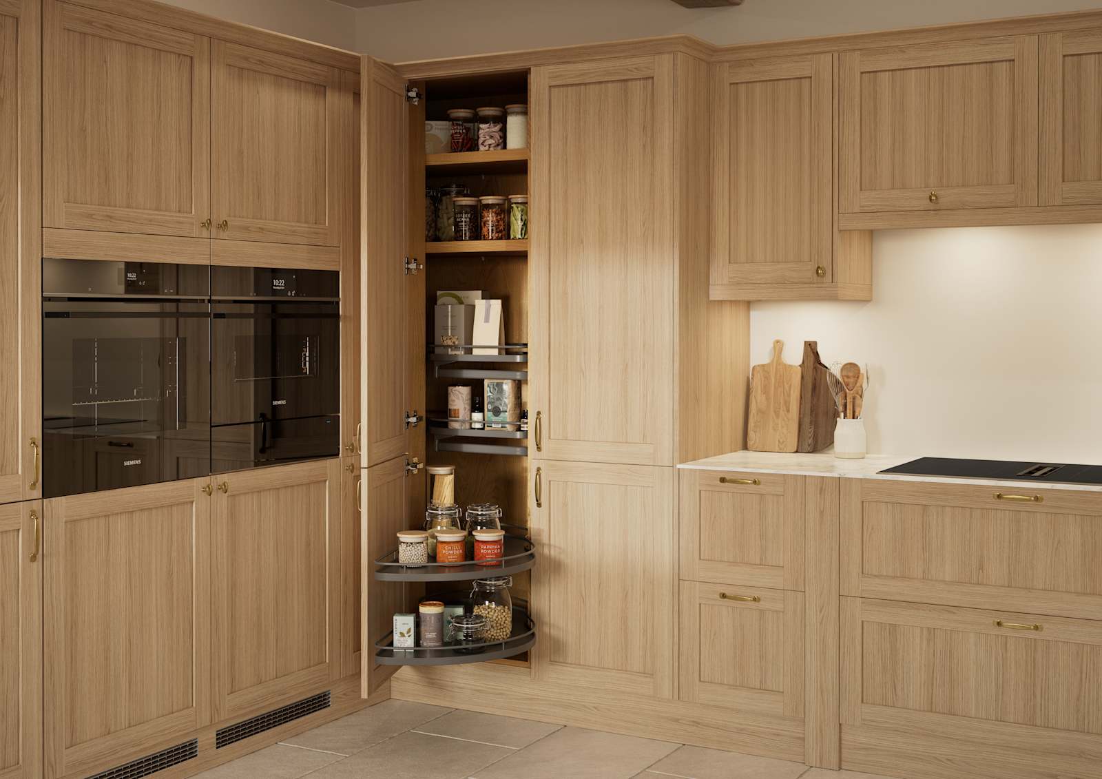 Traditional premium contemporary Shaker kitchen Ambleside in oak with brass knobs and handles, built-in ovens in tall cabinetry, opened tall corner cabinet with oak shelves and pull-out carousel.