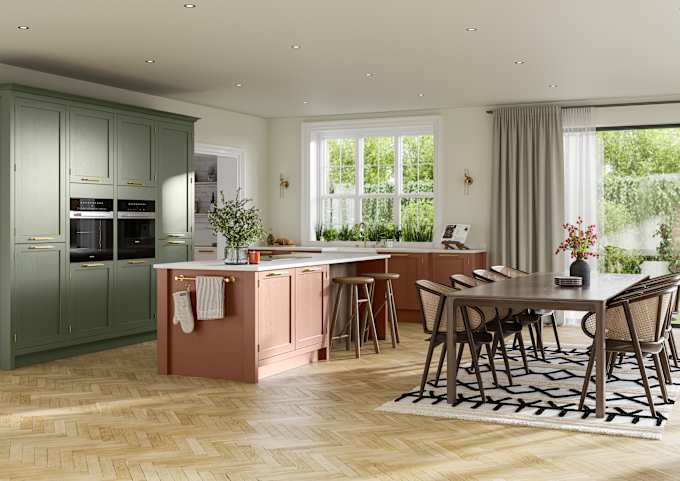 Open floorplan kitchen and dining rool with tall Wardley kitchen cabinetry from Magnet with built-in ovens and a kitchen island, in the shades Thyme and Clay, with a large wooden dining room table.