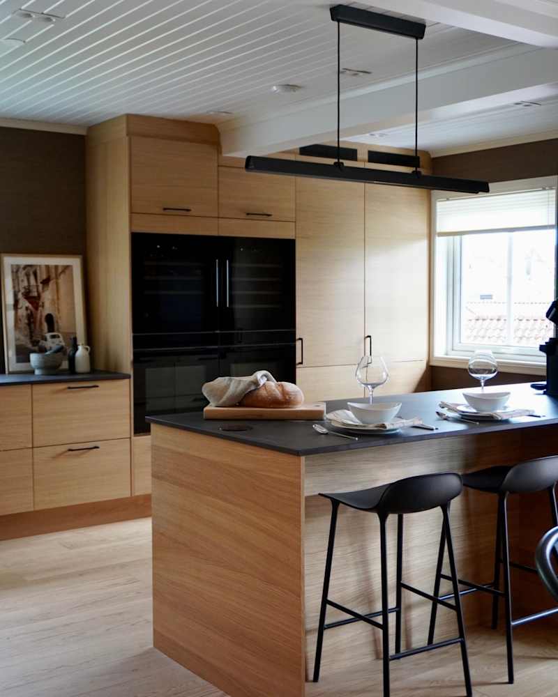 Modern eikekjøkken Amfi Natur fra Sigdal med sort marmor Dekton benkeplate og sorte håndtag.