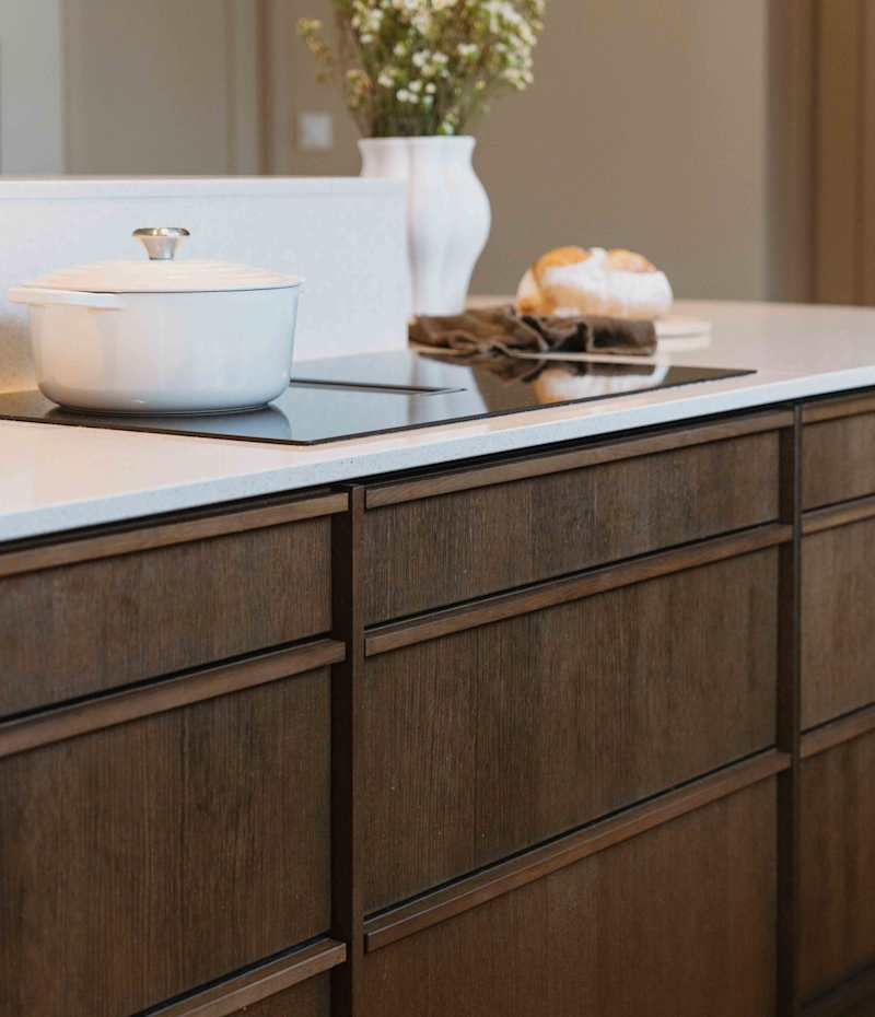 Eikekjøkkenet Favn fra Sigdal i beisfargen Nøtt, matchende tre håndtag, med benkeplate Blanco City fra Silestone.