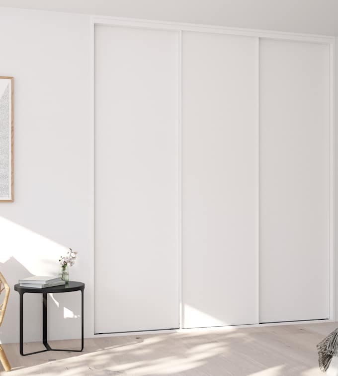 Garderobe i soveværelse med hvid skydedøre