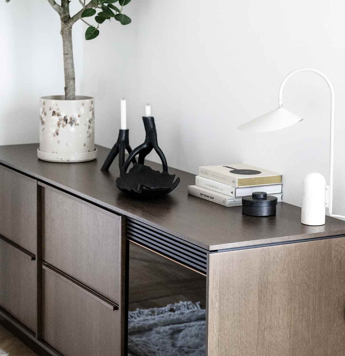 Närbild av bänkskåp med möbelkänsla som sideboard med inbyggd vinkyl, i Signatur Ekbacken brunbetsad ekfanér med matchande handtag.