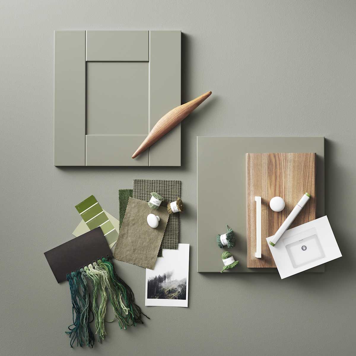 Moodboard med kökslucka i grön shakerstil, vita handtag och knoppar, träprover, färgprover och textiler i gröna toner