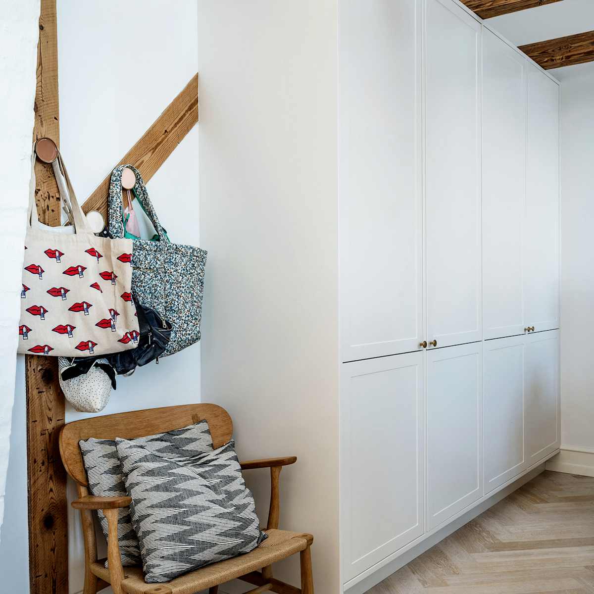 The bespoke wardrobe fits in seamlessly beneath the exposed beams