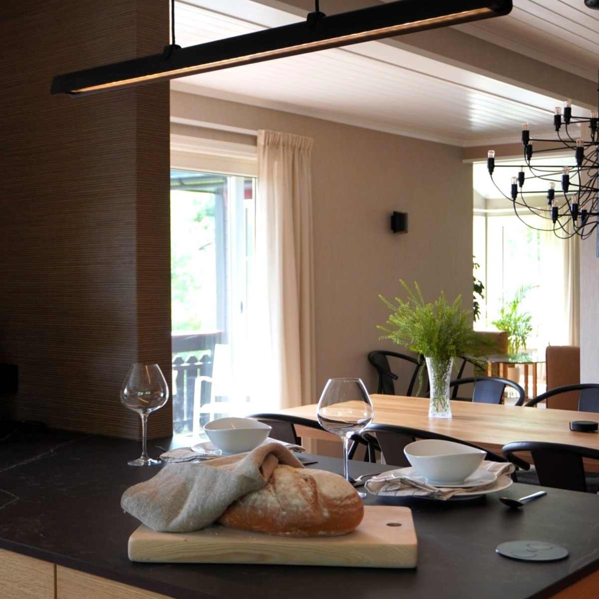 Modern eikekjøkken Amfi Natur fra Sigdal med sort marmor Dekton benkeplate og sorte håndtag.