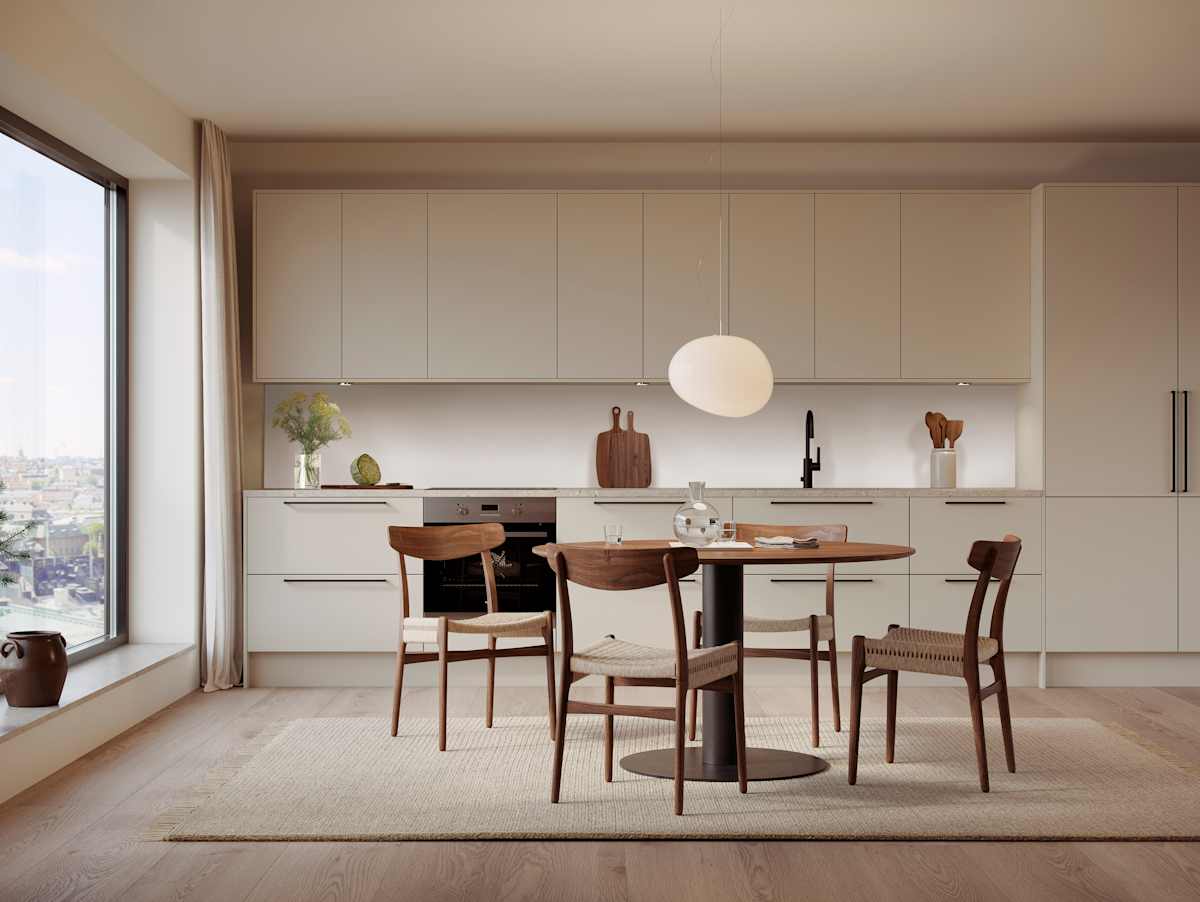 Beige kjøkken med med benkskap, overskap og høyskap, spisebord i tre