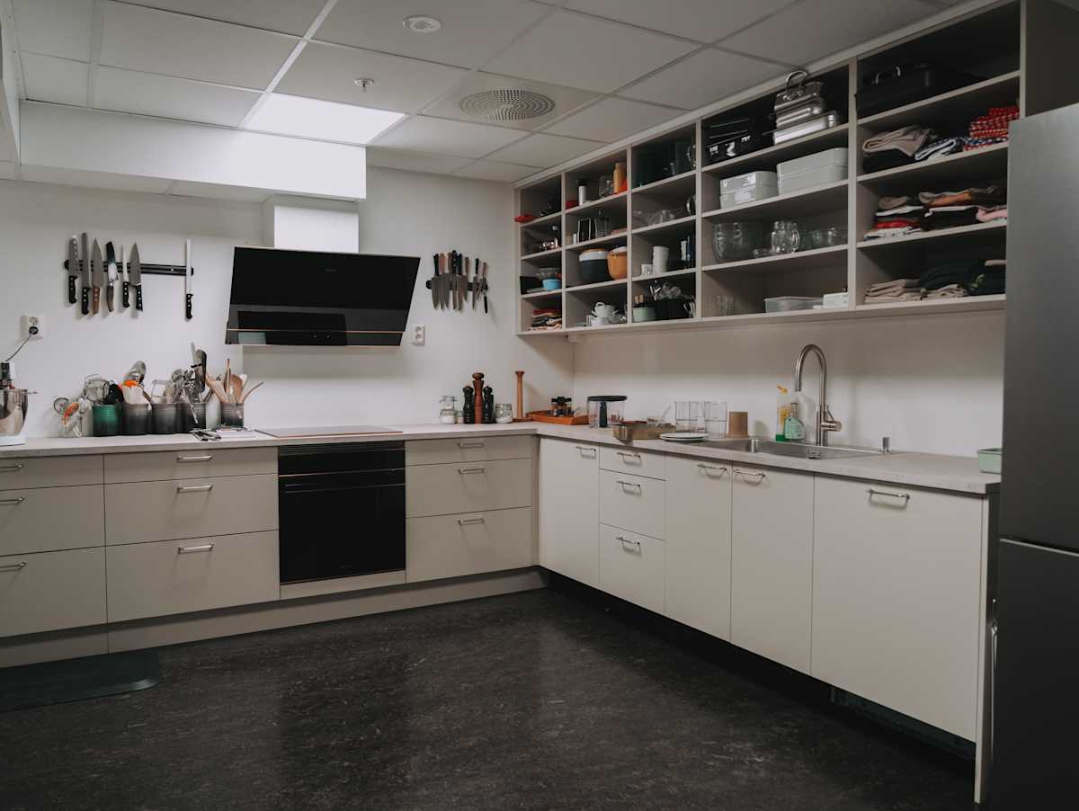 Grovkjøkkenet til kokkene med Vidde korn fra Sigdal, Delaware laminat benkeplate og krom håndtak, Quooker kran og Smeg hvitevarer.
