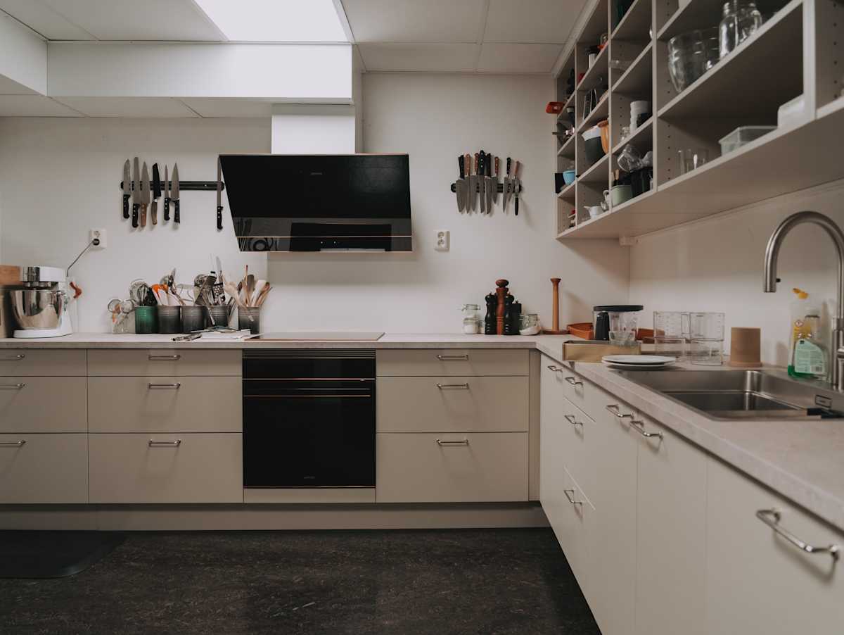 Grovkjøkkenet til kokkene med Vidde korn fra Sigdal, Delaware laminat benkeplate og krom håndtak, Quooker kran og Smeg hvitevarer.