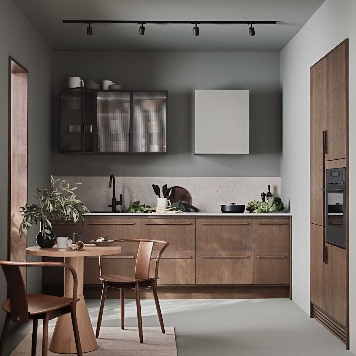 Køkken Forever Oak fra INVITA, mørk eg køkkenskabe med massiv tre mørk eg håndtag, komposit bordplade, sort armatur og vitrineskab med riflede glas i tynd, sort aluminiumsramme