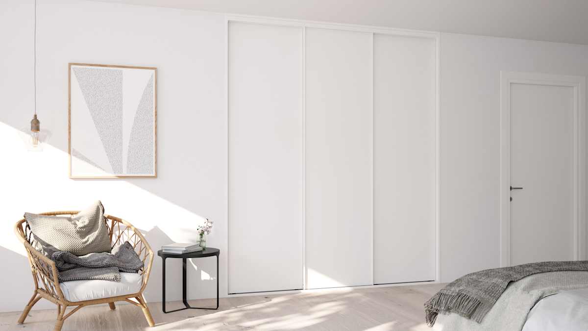 Garderobe i soveværelse med hvid skydedøre