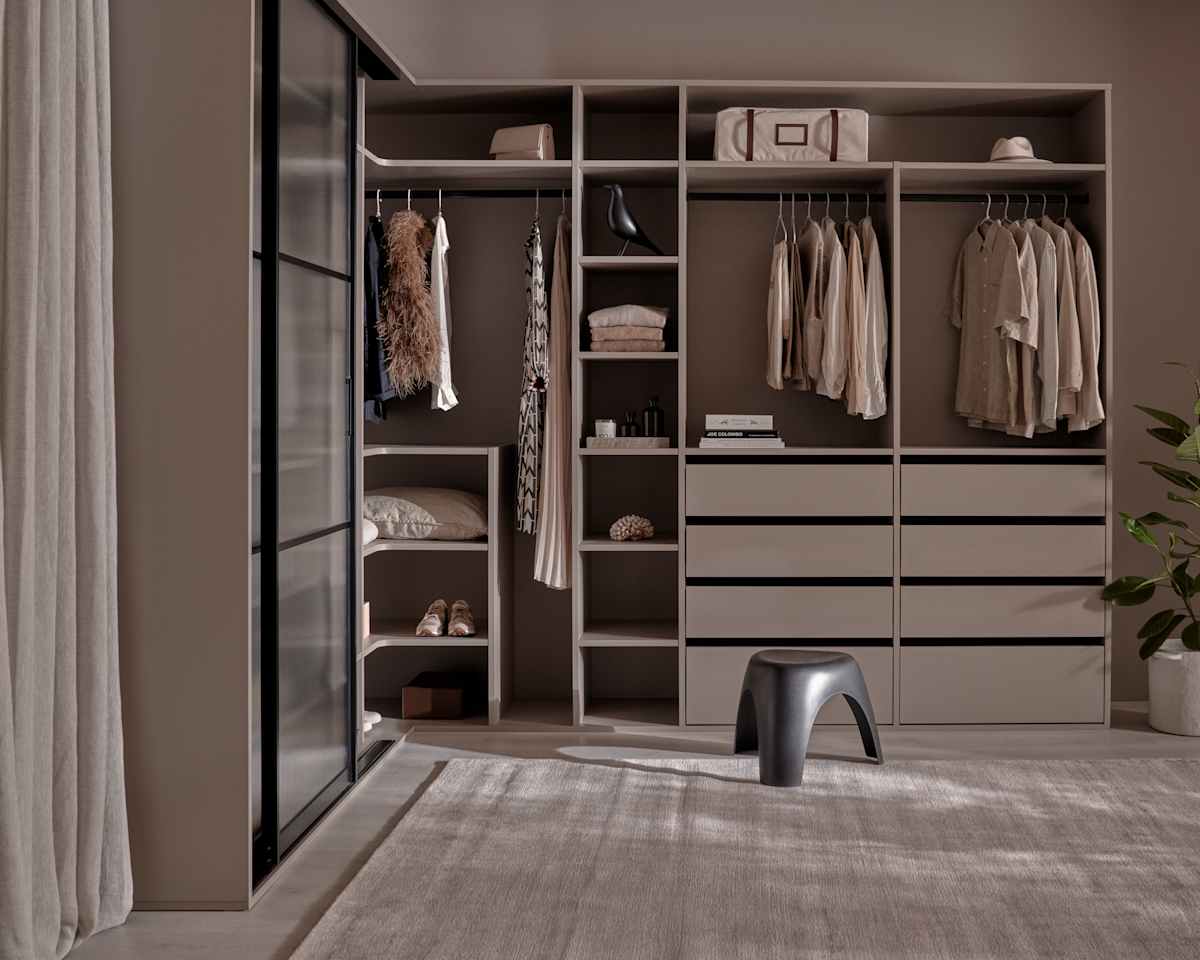 Walk-in garderobe med glasskydedøre med sort metalramme