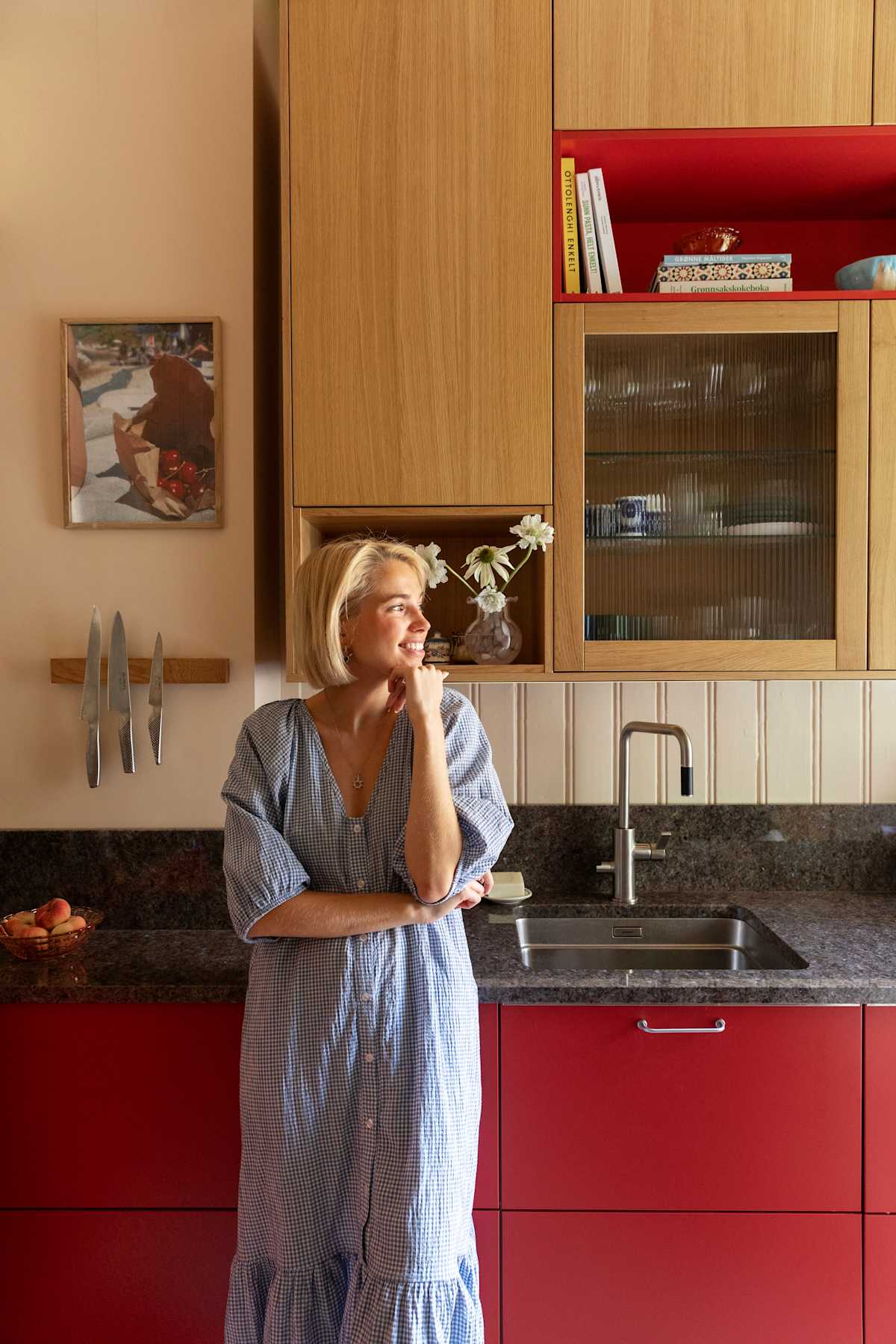 Thea Sofie Loch Næss  i Kirsebær-kjøkkenet sin fra Sigdal med Favn, eikefinér i beisfargen Natur og norsk naturstein benkeplate.