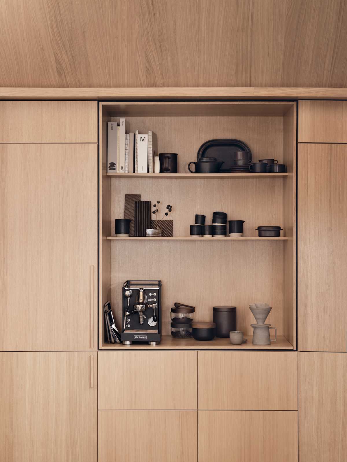 Eikekjøkken Favn Natur fra Sigdal i eikefiner med vertikal trestruktur, høyskap og et åpent skap med plass til kaffemaskin, innrammet med en skyggelegging som skaper et arkitektonisk premiumpreg.