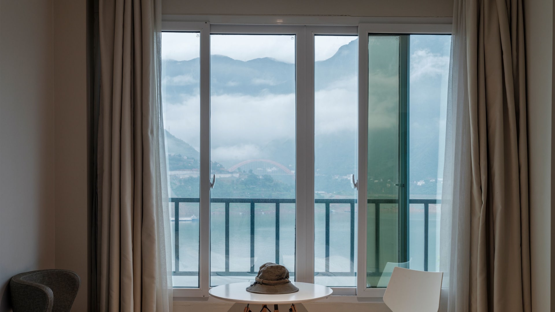 A bright hotel room with a view of the mountains