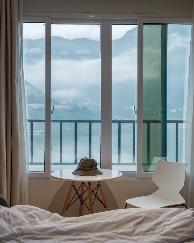 A bright hotel room with a view of the mountains
