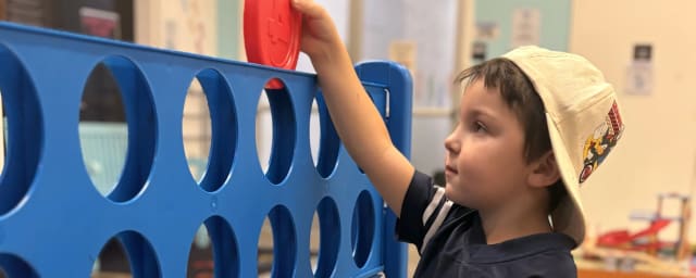child playing giant Connect Four at museum — Chico Children's Museum, from its own website