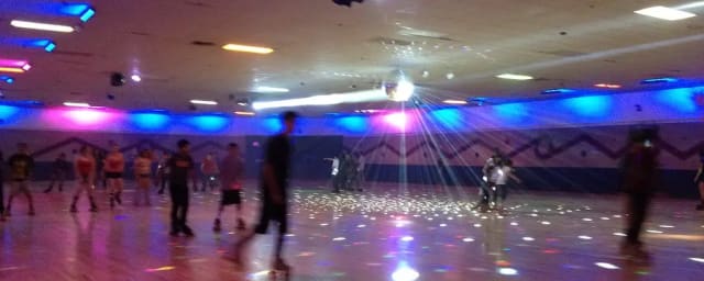 roller rink floor with skaters and disco ball — Skating Plus, from its own website