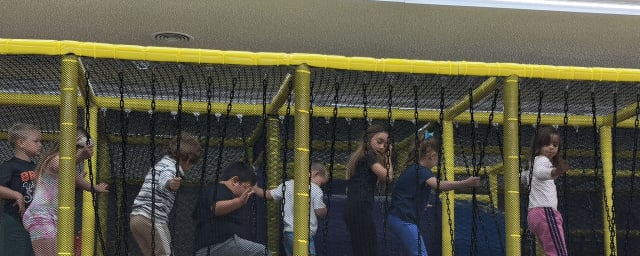 indoor play structure with children on padded climbing/swing — Willits Kids Corner, from its own website