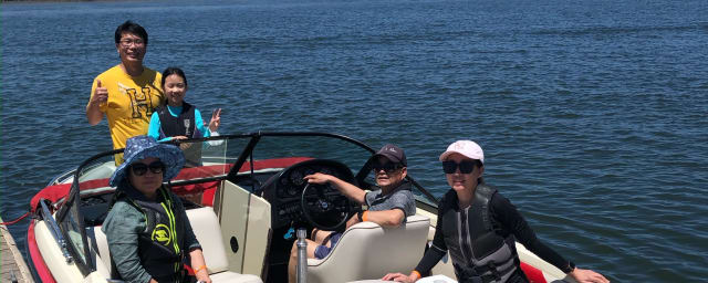 family posed on the boat they are renting/using at the venue — Delta Steve's Boating Adventures, from its own website
