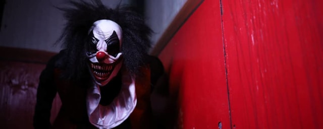 scary clown actor in costume at haunted attraction — The Haunted Trail of Balboa Park, from its own website