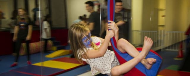 photograph of child using therapy swing at gym — We Rock the Spectrum Redondo Beach Kids Gym, from its own website