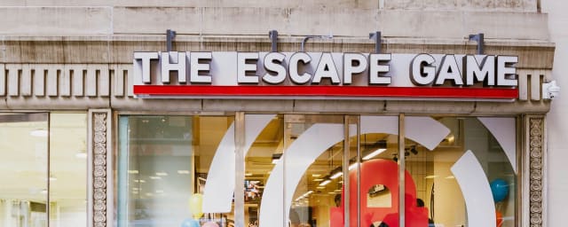 Storefront with 'THE ESCAPE GAME' sign, glass doors with circular lock graphic, people inside — The Escape Game King Of Prussia, from its own website