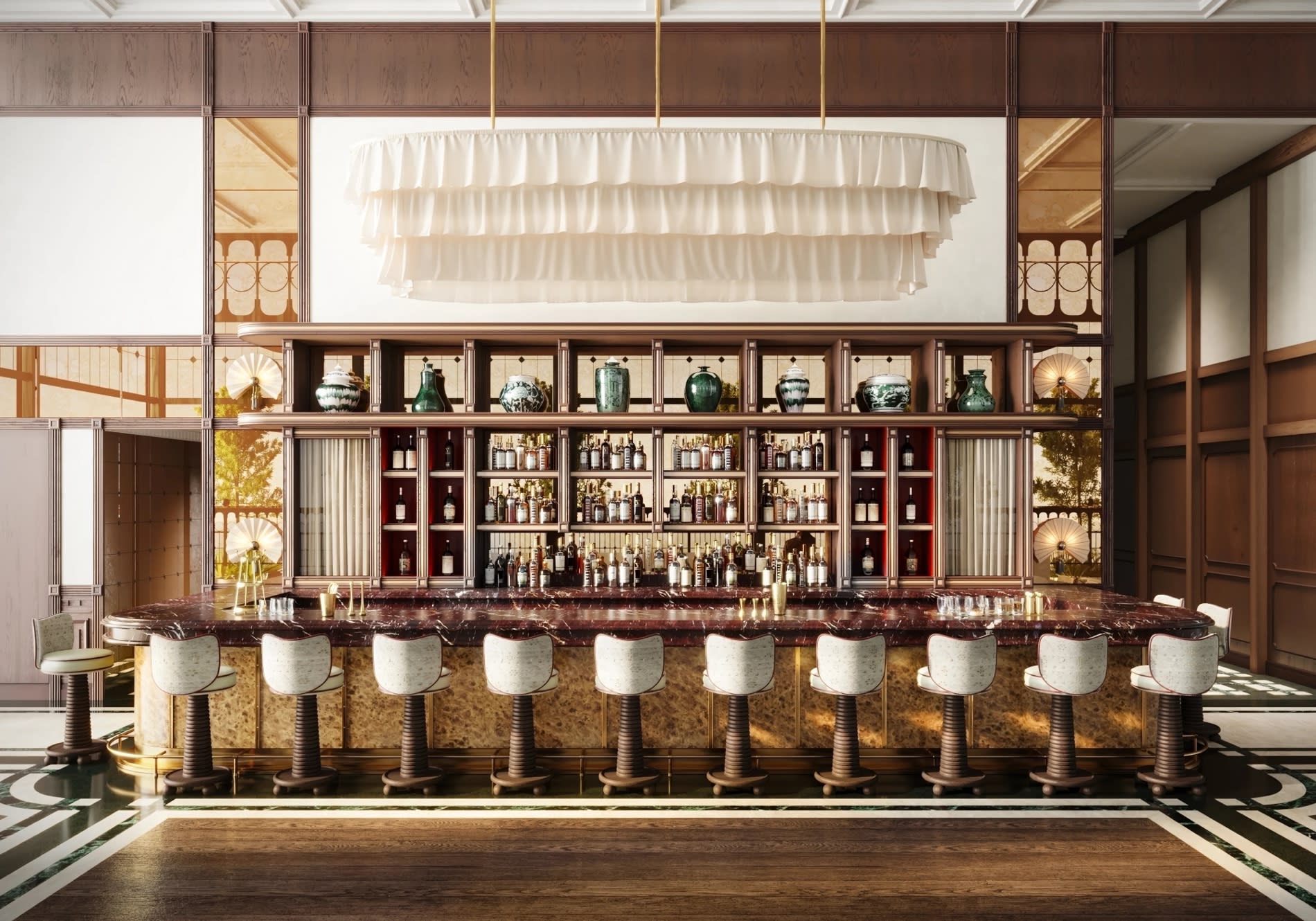 Ansicht der Bar Lu im NoMad Singapore mit Tresen, Hockern und grossem Kronleuchter