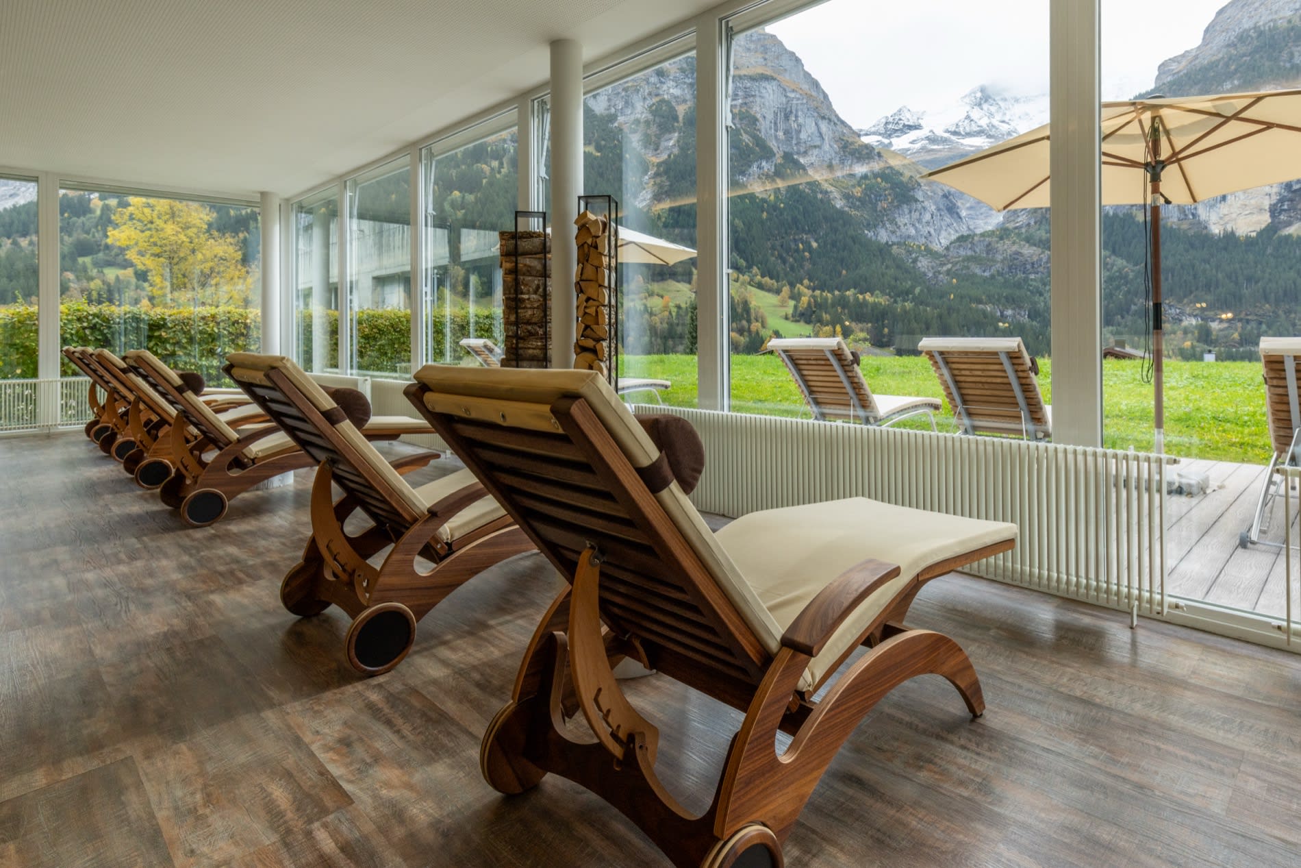 Transats en bois du spa du Sunstar Grindelwald face aux vitres et à l'Eiger