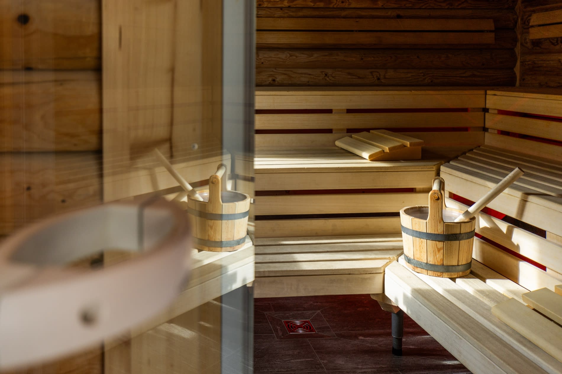 Intérieur en bois du sauna finlandais du Sunstar Grindelwald, seaux et lumière chaude