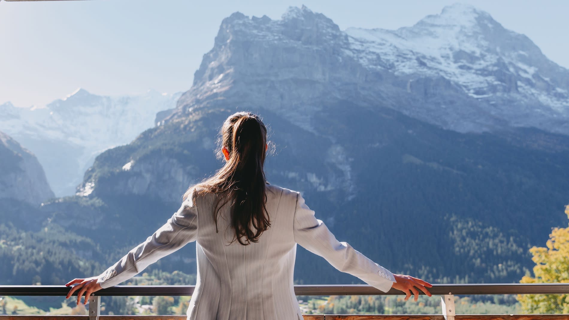 Cliente au balcon d'une chambre Premium du Sunstar Grindelwald, face à l'Eiger
