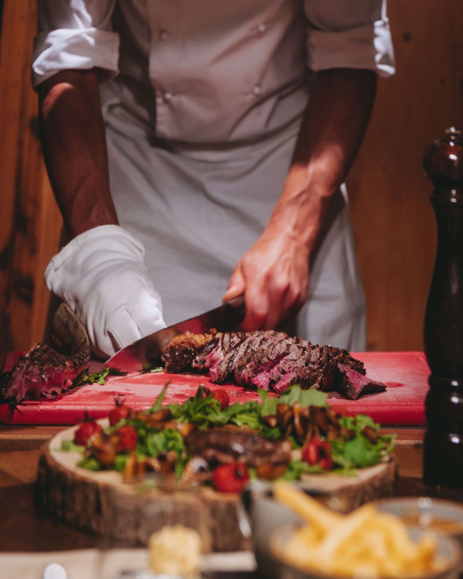 Chef découpant un tomahawk d'Angus suisse à l'Adlerstube du Sunstar Grindelwald