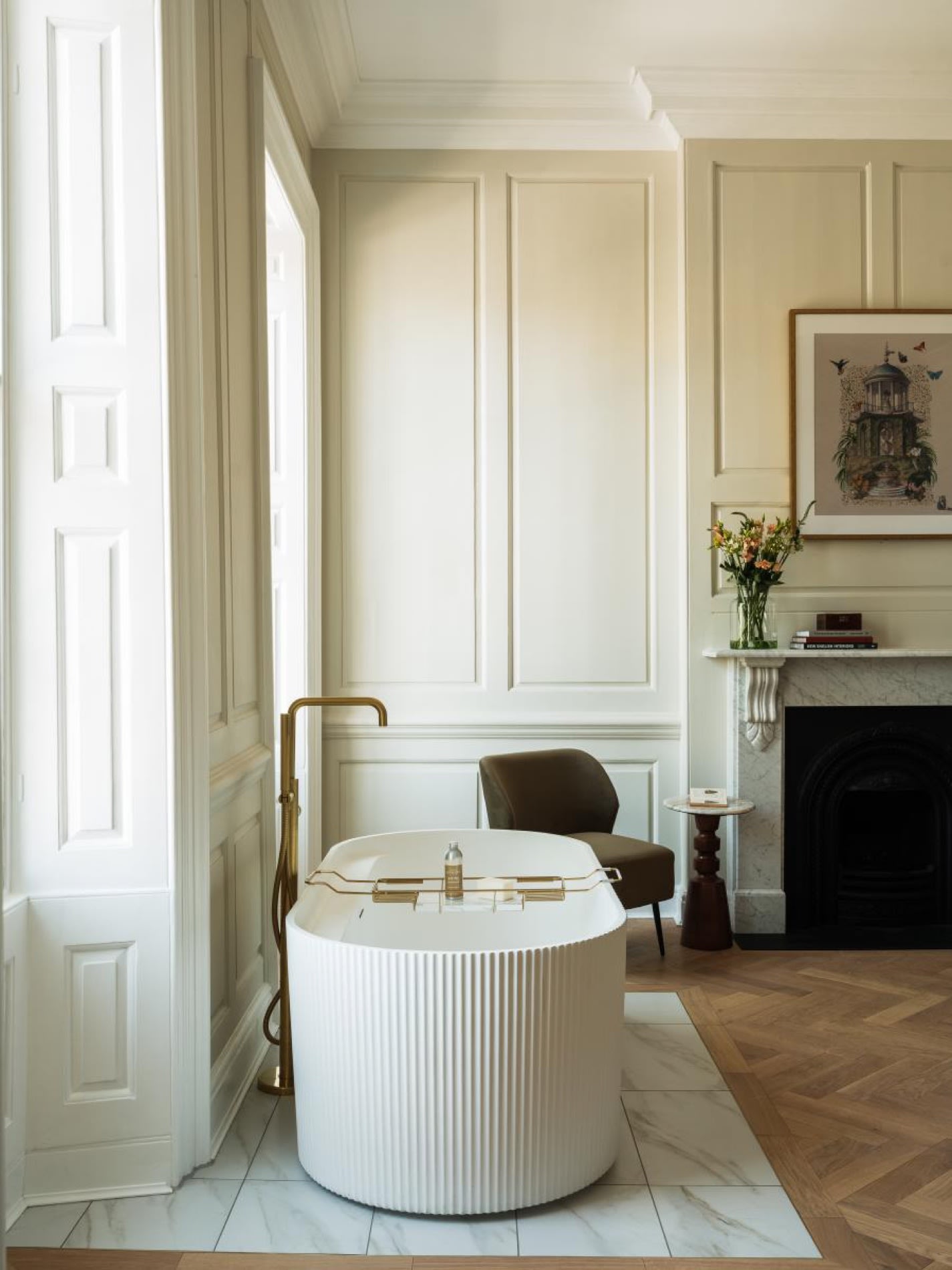 Cuarto de baño del Parade Hotel Bath, bañera blanca y grifería dorada frente a los paneles de madera