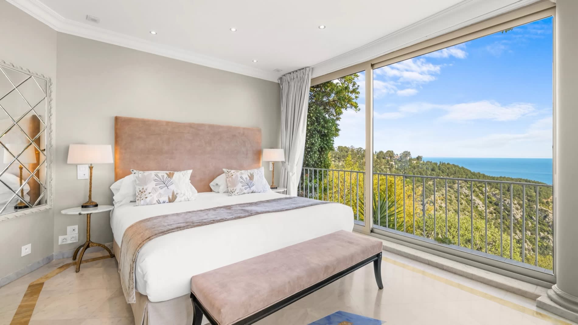 Panoramic suite at Château de la Chèvre d'Or in Èze, with bed facing the floor-to-ceiling window and the sea