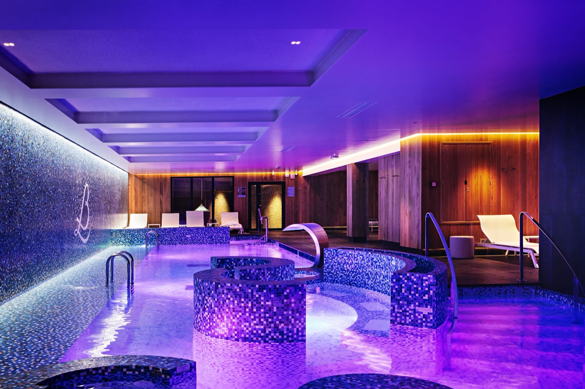 Le grand bassin en mosaïque du spa Loiseau des Sens, éclairé de violet, au Relais Bernard Loiseau à Saulieu