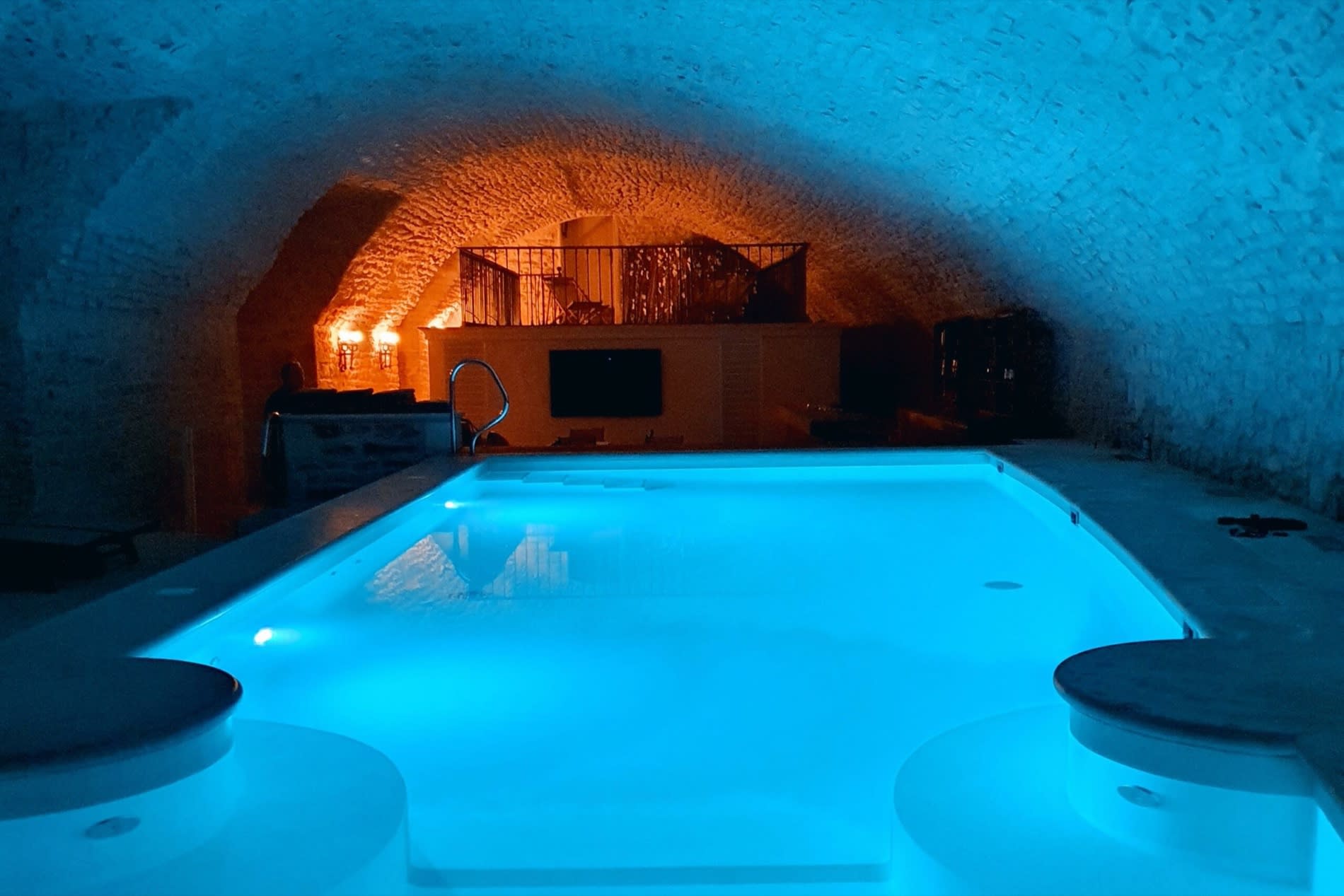 La piscine intérieure du Château de Vault-de-Lugny, éclairée en bleu sous les anciennes caves voûtées, près de Vézelay