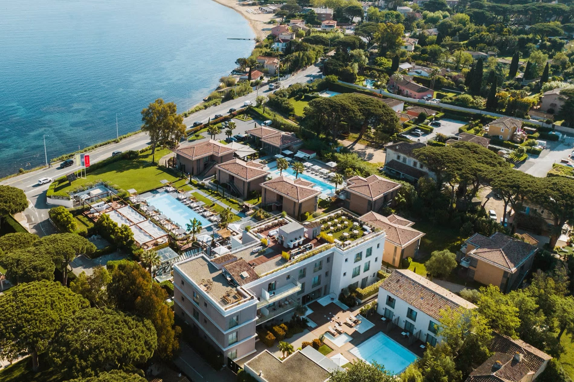 Aerial view of the Kube Saint-Tropez hotel, its nine buildings, gardens and pools above the gulf of Saint-Tropez at Gassin
