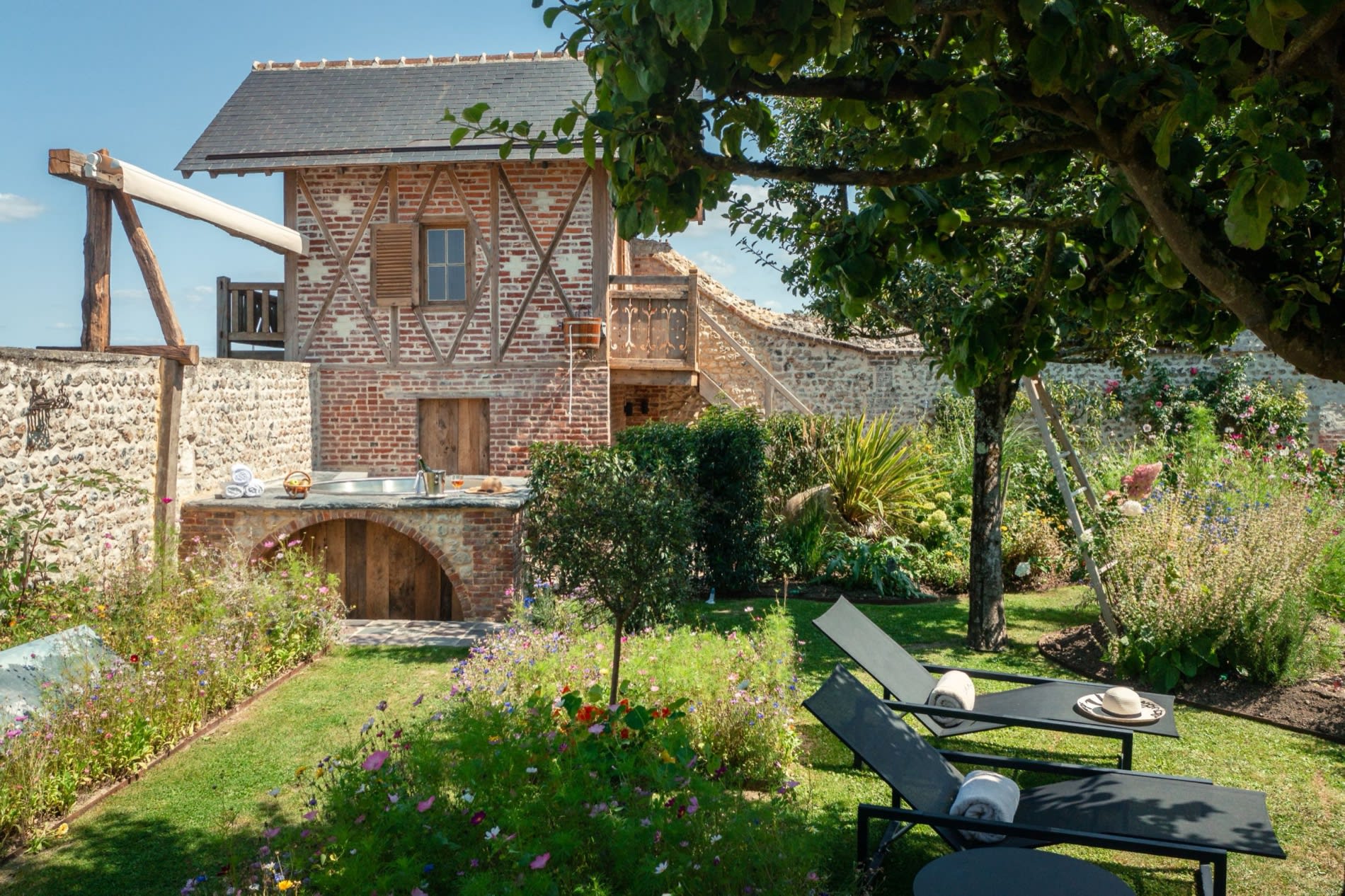 Le bain à remous extérieur du Spa Potager de la Ferme Saint Siméon, devant la bâtisse à colombages, à Honfleur