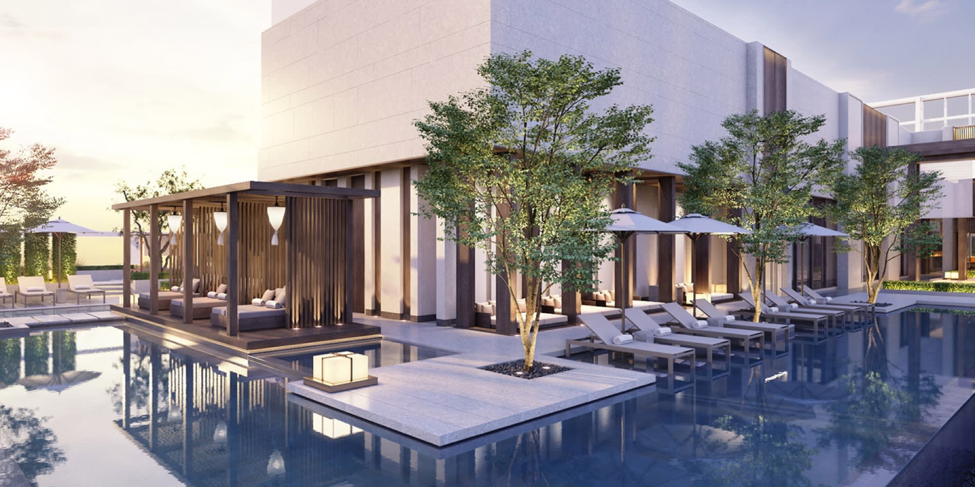 Outdoor pool at the Shilla Monogram Hanoi West Lake, timber cabanas, loungers and trees mirrored in the water at sunset