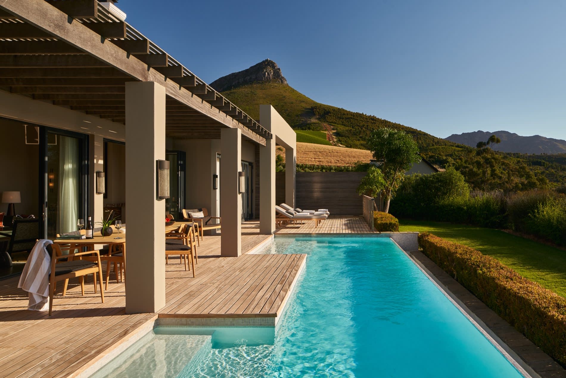 Terraza y piscina de un lodge de Delaire Graff Estate en Stellenbosch, viñedos y montañas de los Winelands sudafricanos