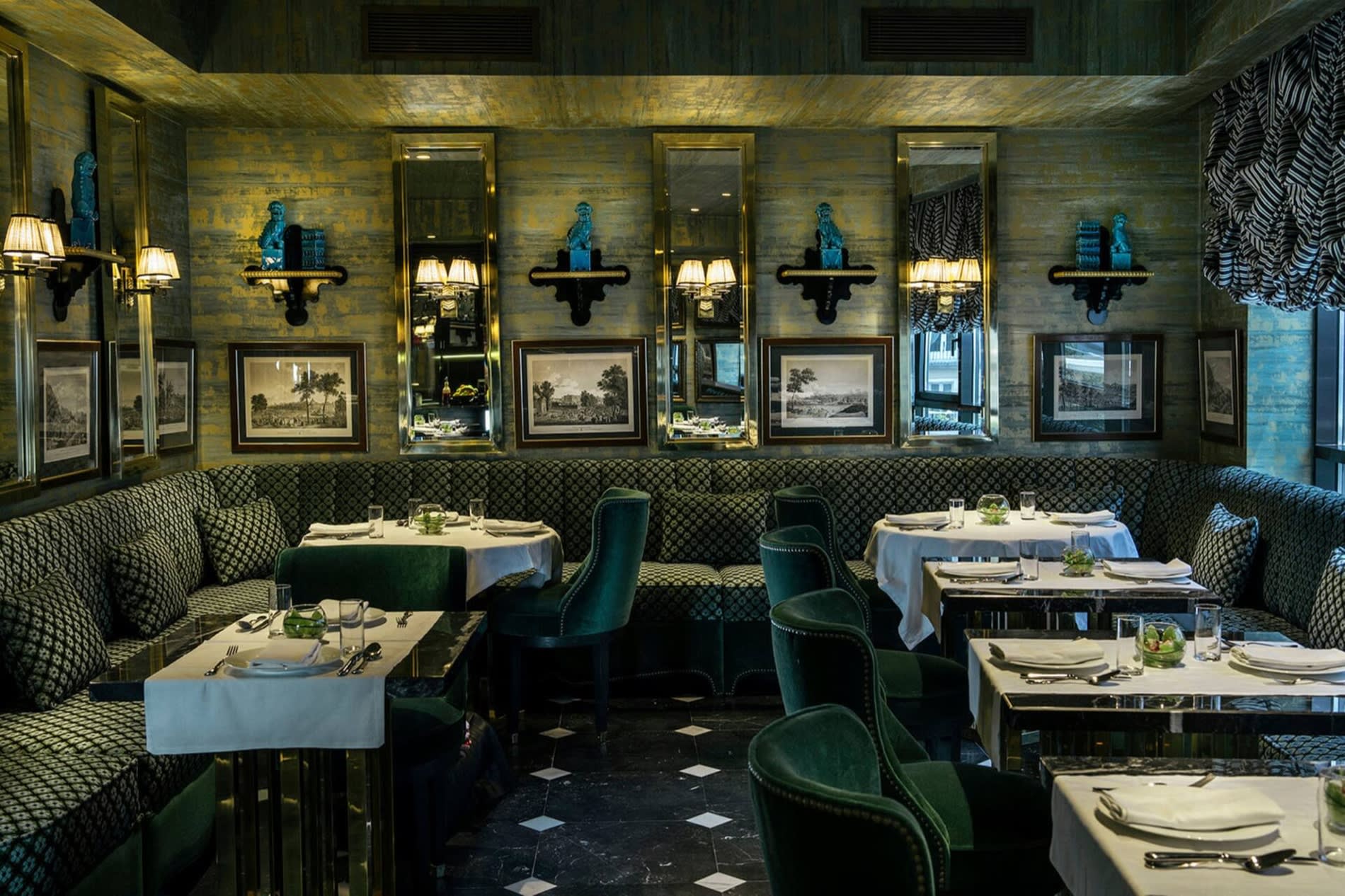 Salon-restaurant de Casa Verbena Madrid, banquettes et fauteuils en velours vert, murs patines dores, miroirs encadres et gravures anciennes