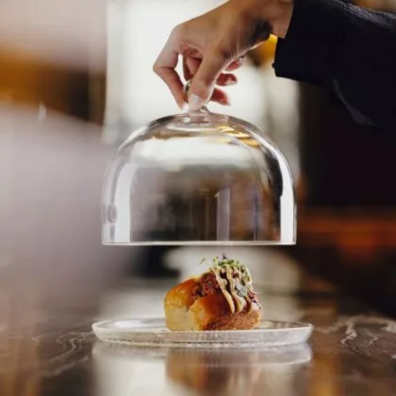 A bite served under a cloche at BLESS Barcelona, part of the collaboration with Hofmann