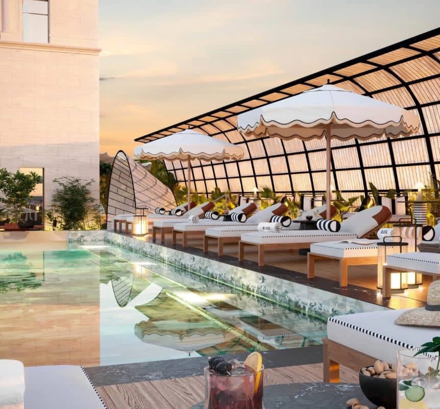 The rooftop pool at BLESS Barcelona, under its pergola, facing the roofs of the Eixample