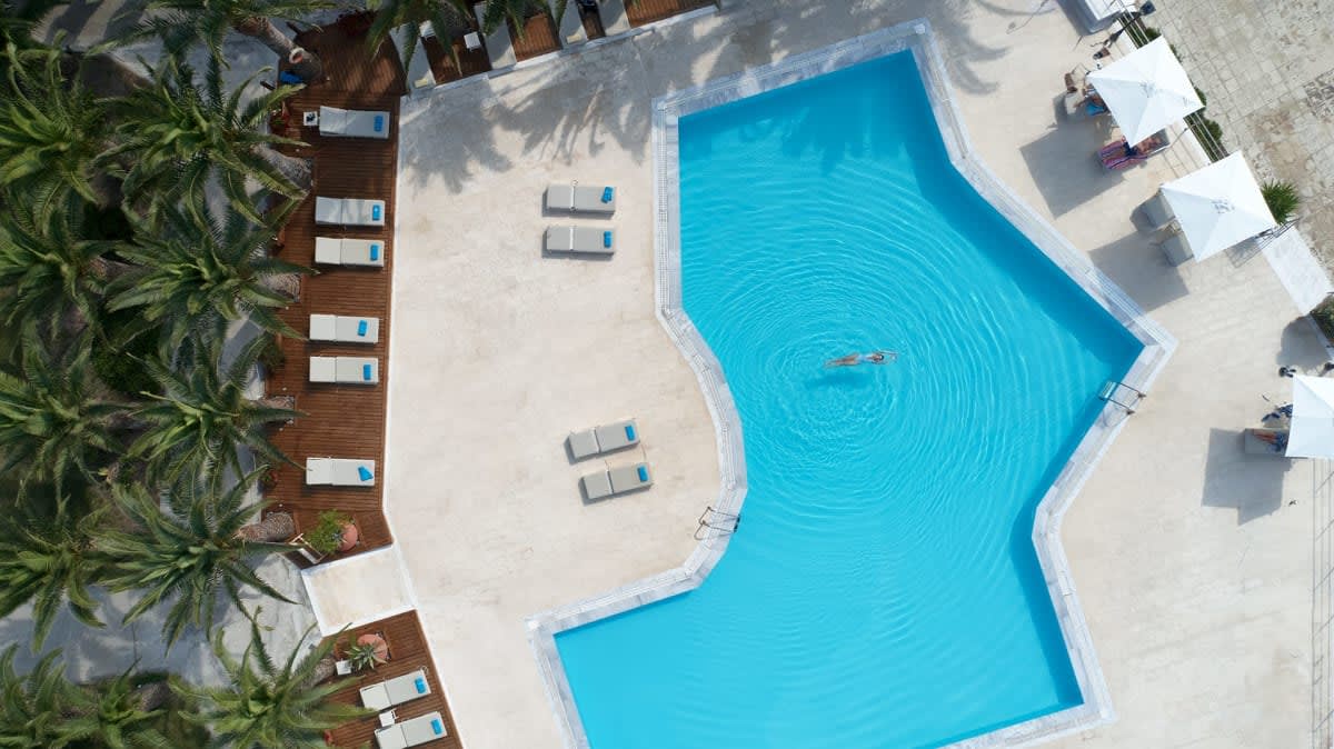 La piscina del hotel Aphrodite vista desde el aire, rodeada de tumbonas y palmeras