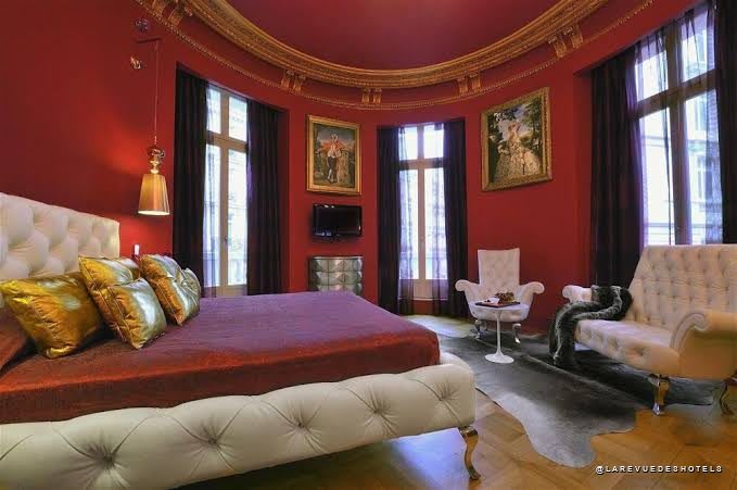 Chambre de l'Hôtel Banke Opéra aux murs pourpres et cadres dorés