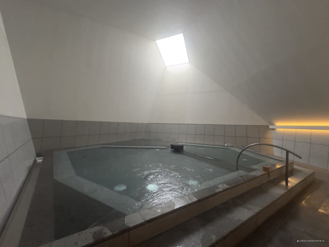 Le bassin de l'onsen de l'OMO7 Osaka avec son puits de lumière ouvert sur le ciel
