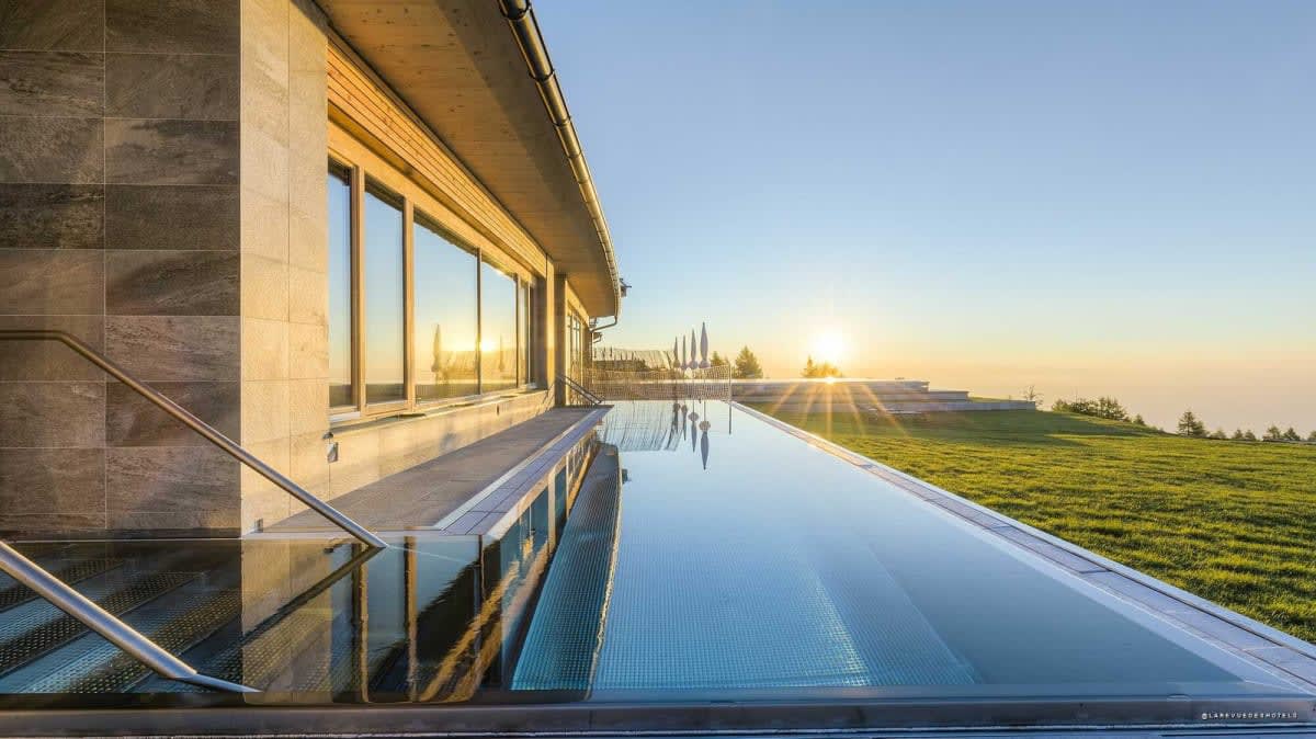 La piscina infinita del Mountain Resort Feuerberg al atardecer, frente a los Alpes