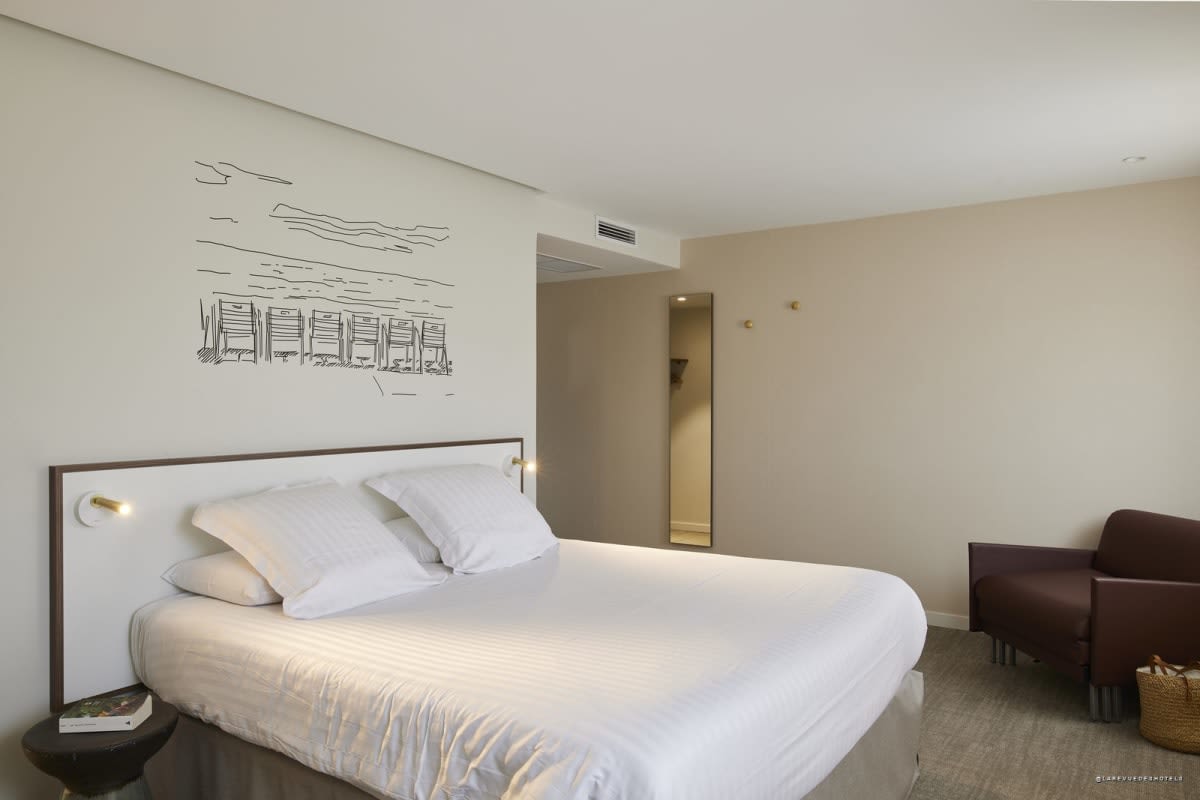 Room with lounge area and armchair at Hôtel du Pin