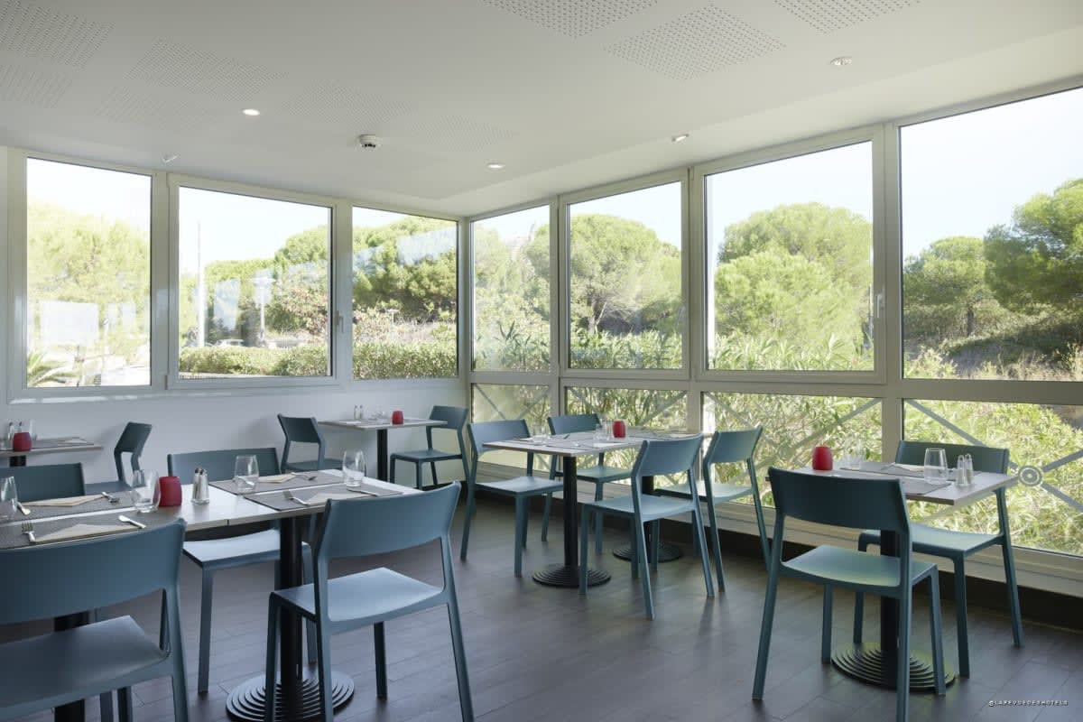 Restaurant room at Hôtel Cyano opening onto greenery in Fréjus