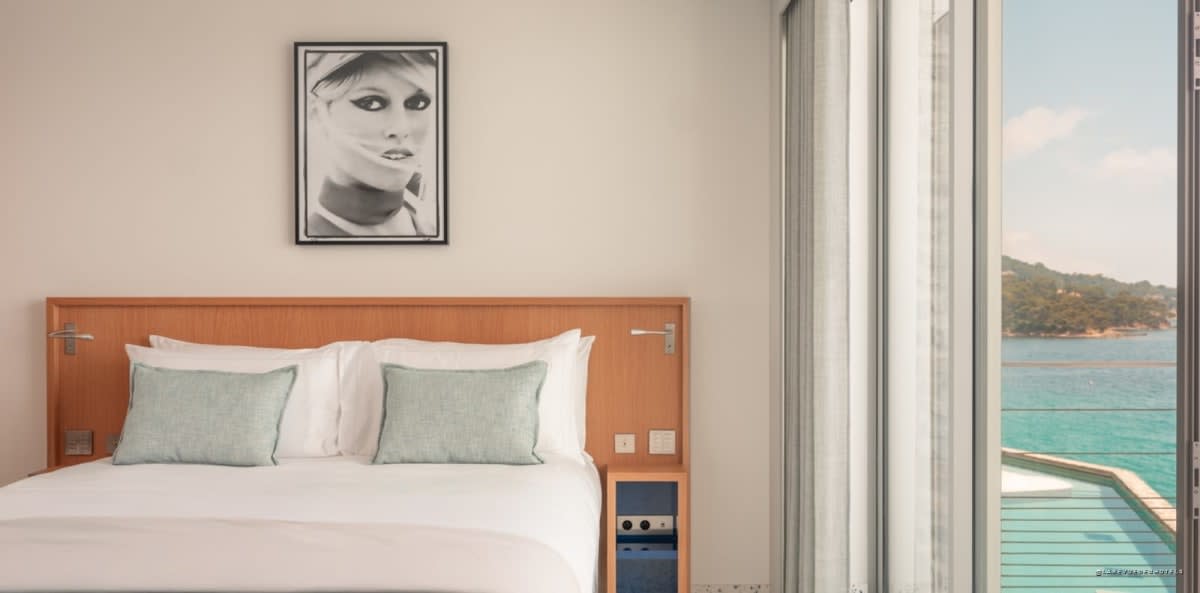 Room at Hôtel Les Roches with framed photograph and cove view